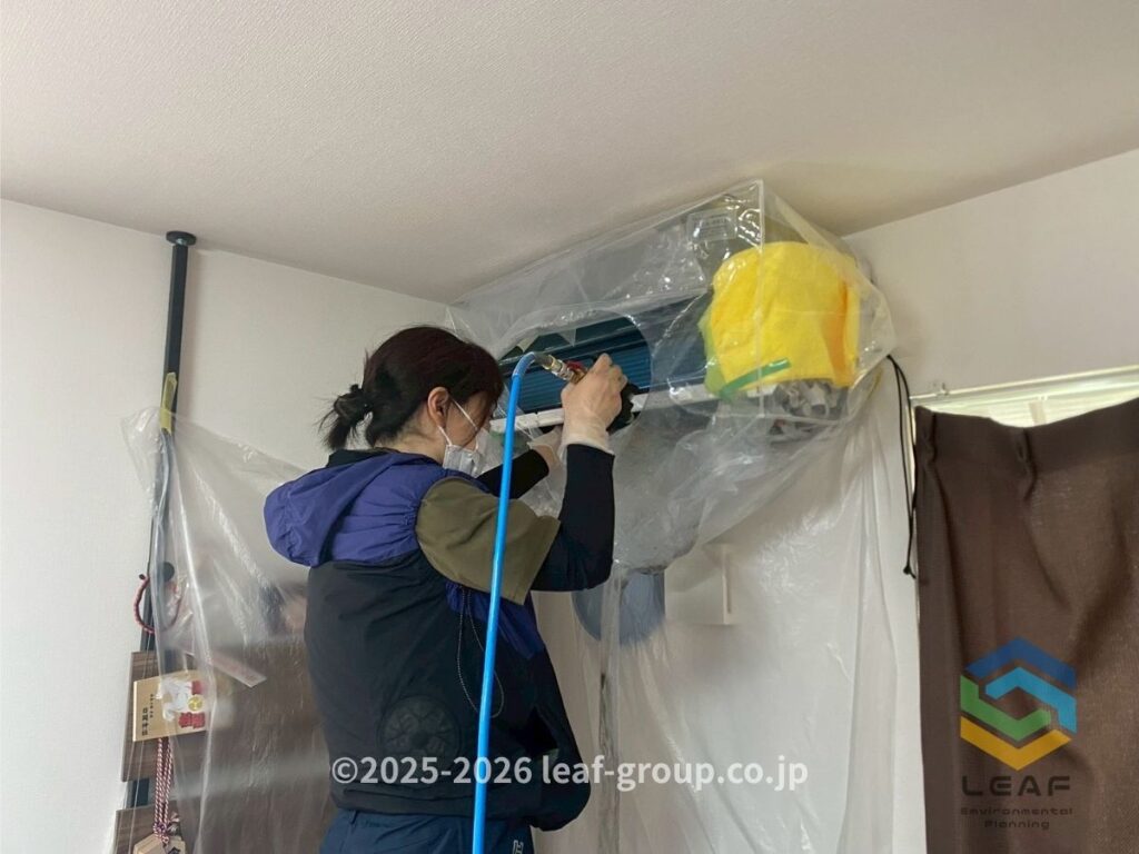 女性スタッフによるエアコンクリーニング作業中